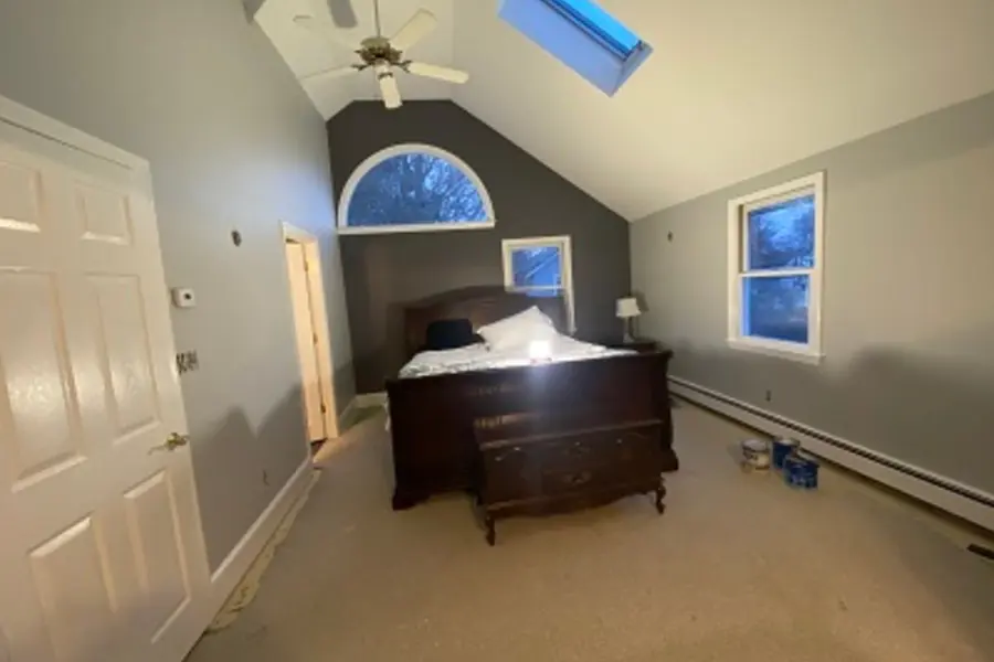 Painter cutting a clean line along ceiling trim