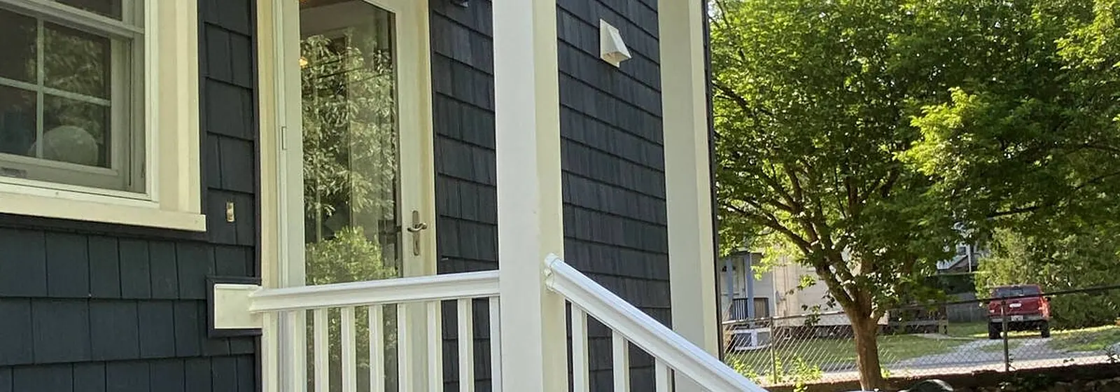 Dark gray home with a new white-railed porch and steps