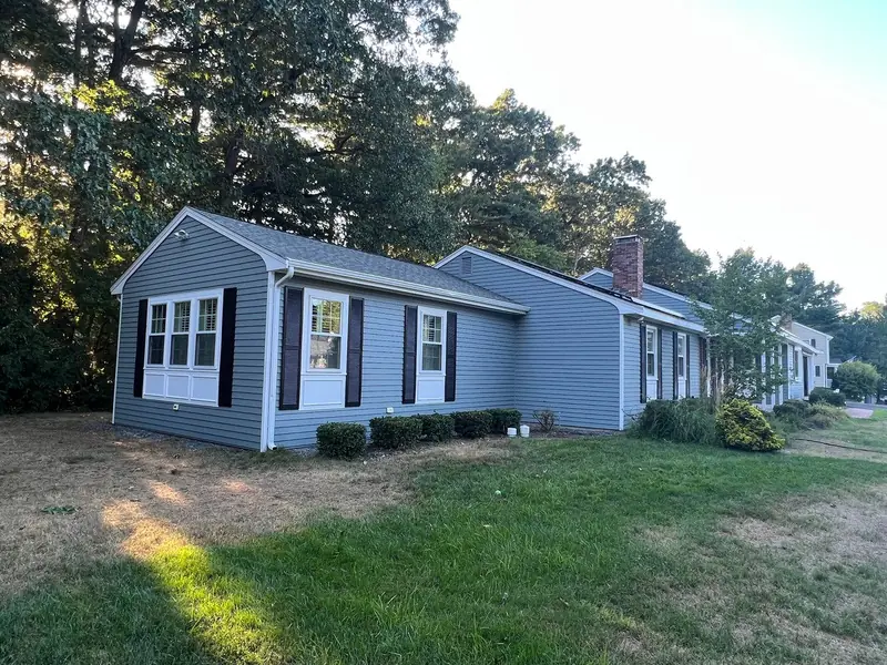 Gray ranch home with black shutters after painting