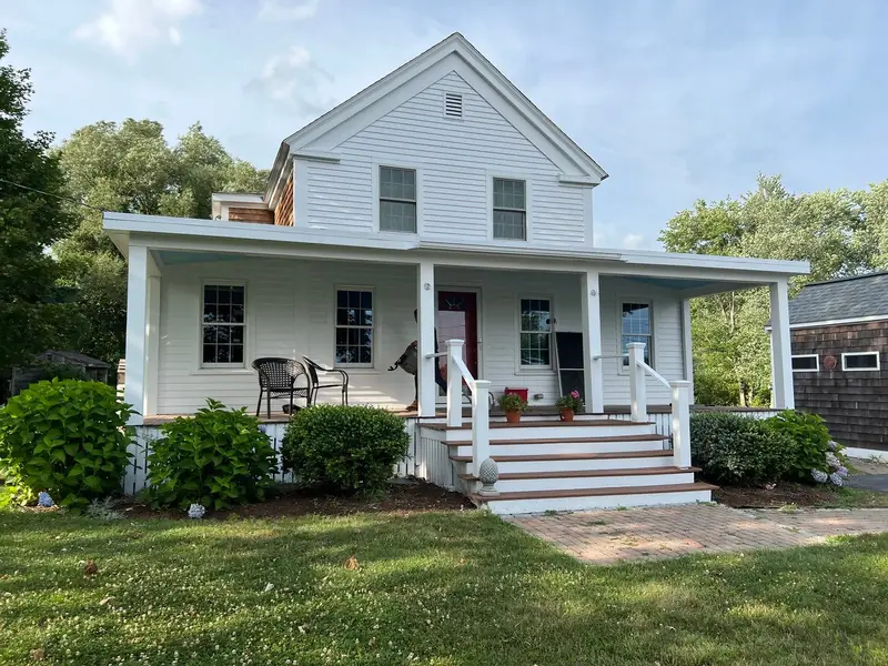 White farmhouse with a wraparound porch