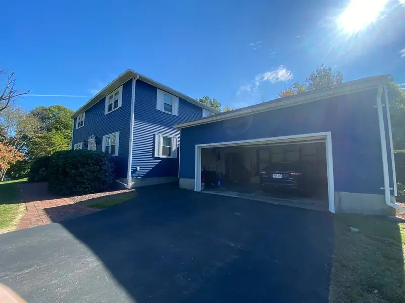 Blue two-story home with white trim and a two-car garage