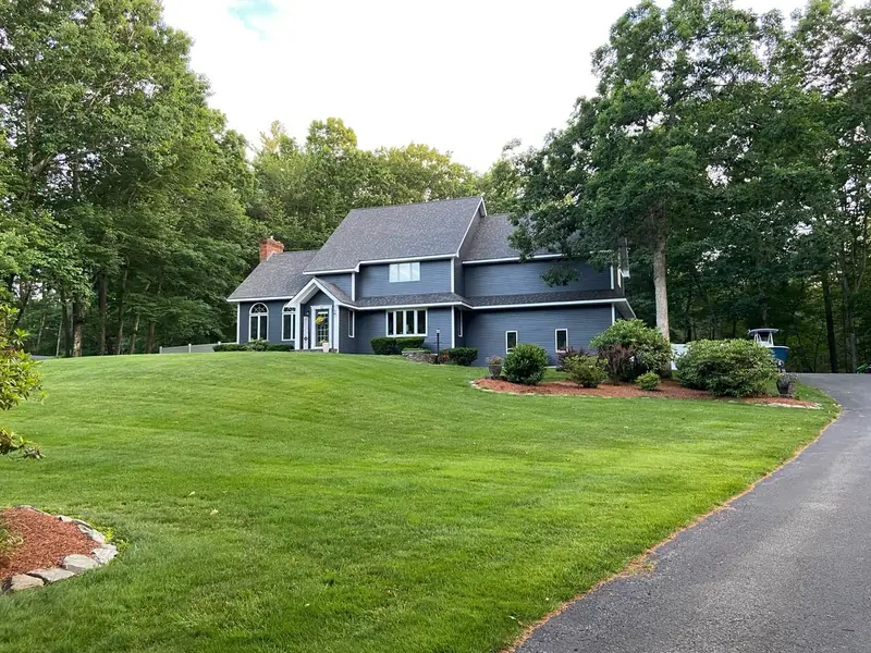 Dark gray home with white trim on a wooded lot