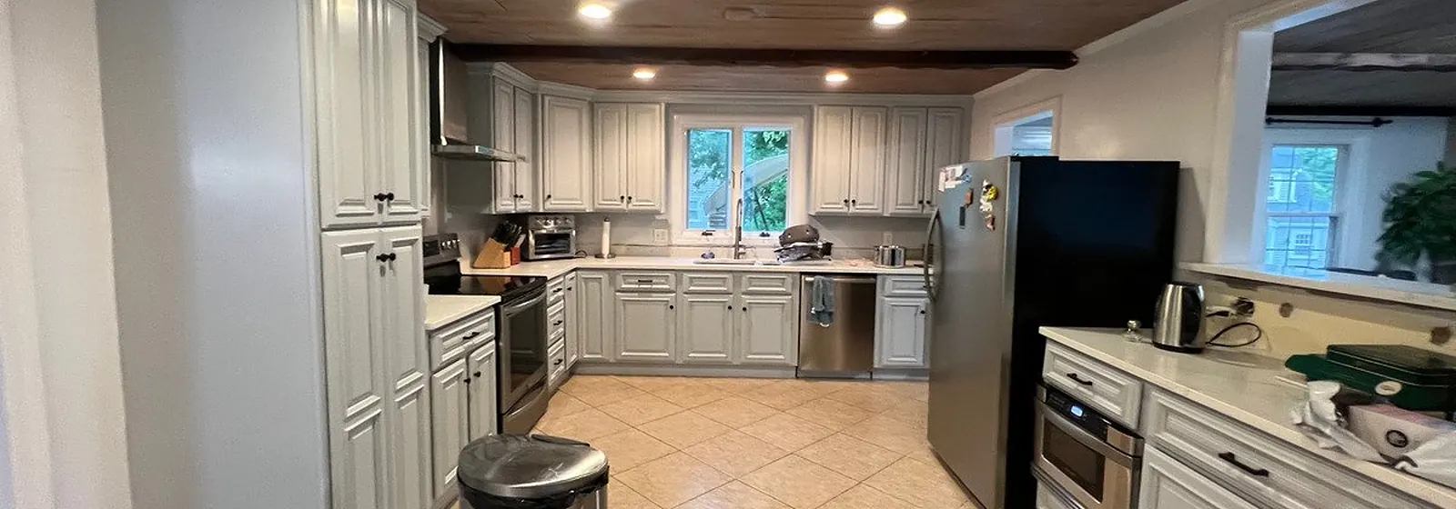 Living room with freshly painted white walls and a wood ceiling